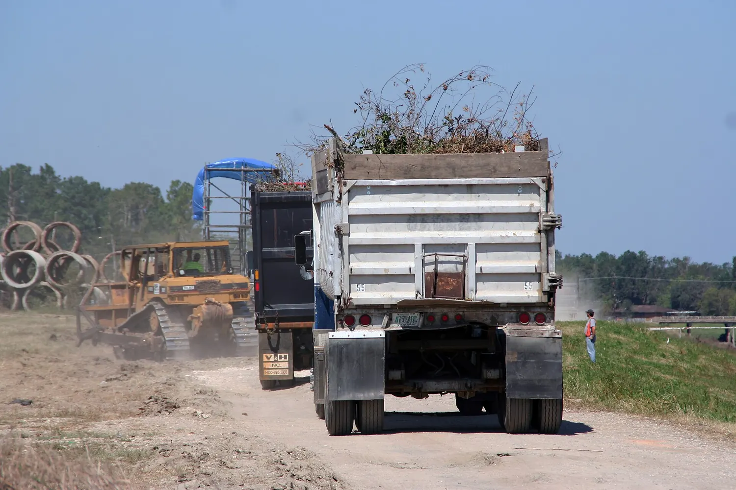 Dump trucks hauling storm debris out of a residential street